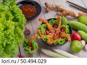 Shrimp deep fried batter placed on salad and tomatoes in a wooden bowl. Стоковое фото, агентство Ingram Publishing / Фотобанк Лори