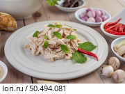 The chicken that is bordered is cooked and placed in a white plate along with mint leaves. Стоковое фото, агентство Ingram Publishing / Фотобанк Лори
