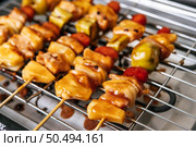 BBQ grill with a variety of meats, complete with tomatoes and bell peppers. Стоковое фото, агентство Ingram Publishing / Фотобанк Лори