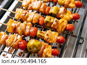 BBQ grill with a variety of meats, complete with tomatoes and bell peppers. Стоковое фото, агентство Ingram Publishing / Фотобанк Лори