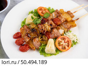 BBQ with a variety of meats, complete with tomatoes and bell peppers on a white plate. Стоковое фото, агентство Ingram Publishing / Фотобанк Лори