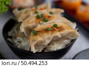 Gyoza in a black cup with Sushi. Selective focus. Стоковое фото, агентство Ingram Publishing / Фотобанк Лори