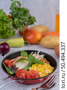 Stir fried noodle that combines corn, golden needle mushroom, tomato, sausage, edamame and spring onions in a frying pan. Стоковое фото, агентство Ingram Publishing / Фотобанк Лори