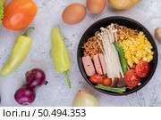 Stir fried noodle that combines corn, golden needle mushroom, tomato, sausage, edamame and spring onions in a frying pan. Стоковое фото, агентство Ingram Publishing / Фотобанк Лори