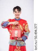 Man wear Cheongsam ready to give red bag to sister for surprising in traditional day. Стоковое фото, агентство Ingram Publishing / Фотобанк Лори