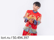 Man wear Cheongsam suit  give gold to his relative for lucky in chinese new year. Стоковое фото, агентство Ingram Publishing / Фотобанк Лори