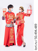 Men and women wear cheongsam welcome to get - get gift money and red bag for traditional day. Стоковое фото, агентство Ingram Publishing / Фотобанк Лори
