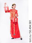 Woman wear Cheongsam suit and black shoe glad getting red bag for surprising in chinese new year. Стоковое фото, агентство Ingram Publishing / Фотобанк Лори