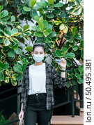 Portrait of young Asian woman in protection mask, eyeglasses on head standing with shopping paper bag. And show credit card in hand,  Lifestyle and shopping concept, copy space. Стоковое фото, агентство Ingram Publishing / Фотобанк Лори