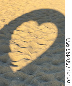 Leftover projection of heart-shaped shadow of structure on beach sand with numerous footprints. Стоковое фото, агентство Ingram Publishing / Фотобанк Лори
