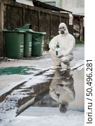 Disinfection specialist man in personal protective equipment (ppe) suit, gloves, mask and face shield, cleaning Quarantine area with a bottle of pressurized spray disinfectant to remove coronavirus. Стоковое фото, агентство Ingram Publishing / Фотобанк Лори