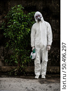 Portrait Disinfection specialist man in PPE suit, gloves, mask and face shield performing public decontamination, standing with feel tired during disinfectant to remove covid-19. Стоковое фото, агентство Ingram Publishing / Фотобанк Лори
