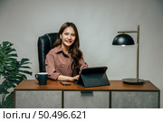 Happily Young asian woman with new normal, she Stay at home and works from home on digital tablet and use smartphone during self-isolation and quarantine covid-19 coronavirus outbreak. Стоковое фото, агентство Ingram Publishing / Фотобанк Лори