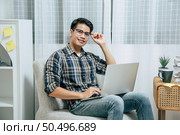 Young handsome man wearing eyeglasses with new normal, Stay at home and works from home on laptop computer while self-isolation and quarantine covid-19 coronavirus outbreak. Стоковое фото, агентство Ingram Publishing / Фотобанк Лори