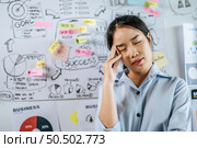 Young asian woman standing and thoughtful how to present planing of project on board in meeting room, copy space. Стоковое фото, агентство Ingram Publishing / Фотобанк Лори