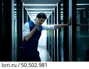 Business man in the corridor of the conference room, Talking to an assistant on the phone to ask for some details. To present results and new projects to the management team for consideration. Стоковое фото, агентство Ingram Publishing / Фотобанк Лори