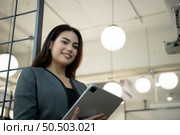 Portrait of Business female rookie in the new entrepreneurial with a tablet as a tool to help in the work. Стоковое фото, агентство Ingram Publishing / Фотобанк Лори