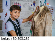 Charming female tailor using the tape measure on the mannequin to cut the shirt at fashion design workshop. Стоковое фото, агентство Ingram Publishing / Фотобанк Лори