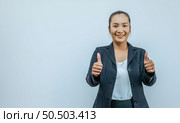 Portrait of Asian woman with two thumbs up sign gesture, isolated on background with copy space area. Positive emotion facial expression feelings, signs and symbols, body language. Стоковое фото, агентство Ingram Publishing / Фотобанк Лори