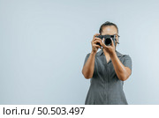 Portrait of Asian woman glasses wearing casual clothes taking a pictures with camera. Isolated background in studio with blank space. Стоковое фото, агентство Ingram Publishing / Фотобанк Лори