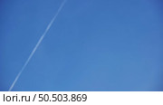 White airplane flying high in clear blue sky leaving contrail. Стоковое видео, видеограф Mikhail Davidovich / Фотобанк Лори