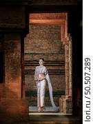 Portrait Asian charming woman wearing beautiful typical Thai dress identity culture of Thailand in ancient temple or famous place with gracefully pose, copy space. Стоковое фото, агентство Ingram Publishing / Фотобанк Лори