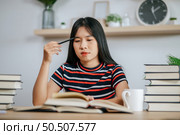 young woman working on a book on the table and having stress. Стоковое фото, агентство Ingram Publishing / Фотобанк Лори