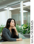 Portrait of a novice businesswoman in a new entrepreneurship. Closing his eyes to rest them in his office room. Стоковое фото, агентство Ingram Publishing / Фотобанк Лори