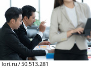 Young entrepreneurs in Asia Meeting to review stock investment information in the meeting room with a coordinator to facilitate various aspects to serve. Стоковое фото, агентство Ingram Publishing / Фотобанк Лори