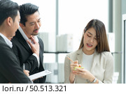 Young entrepreneurs in Asia Organize meetings to brainstorm and review information on glass board to get the best investment conclusion. Стоковое фото, агентство Ingram Publishing / Фотобанк Лори