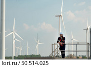 Engineer at Natural Energy Wind Turbine site with a mission to climb up to the wind turbine blades to inspect the operation of large wind turbines that converts wind energy into electrical energy. Стоковое фото, агентство Ingram Publishing / Фотобанк Лори