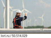 Engineer at Natural Energy Wind Turbine site with a mission to climb up to the wind turbine blades to inspect the operation of large wind turbines that converts wind energy into electrical energy. Стоковое фото, агентство Ingram Publishing / Фотобанк Лори