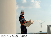 Engineer at Natural Energy Wind Turbine site with a mission to climb up to the wind turbine blades to inspect the operation of large wind turbines that converts wind energy into electrical energy. Стоковое фото, агентство Ingram Publishing / Фотобанк Лори