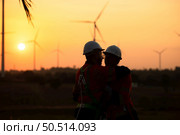 Engineers working on wind farms for renewable energy are responsible for maintaining large wind turbines. Returning from work during while the evening sun shines a beautiful golden light upon both of. Стоковое фото, агентство Ingram Publishing / Фотобанк Лори