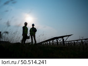 A team of electrical engineers inspecting solar panels in a hundred acre field, in the evening after completing the daily work tasks with the setting sun. Стоковое фото, агентство Ingram Publishing / Фотобанк Лори