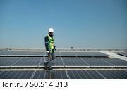 Engineer in charge of solar panel installation The installation of solar energy conversion into electricity for a warehouse is currently being investigated. Стоковое фото, агентство Ingram Publishing / Фотобанк Лори
