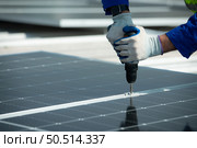 Engineer in charge of solar panel installation The installation of solar energy conversion into electricity for a warehouse is currently being investigated. Стоковое фото, агентство Ingram Publishing / Фотобанк Лори