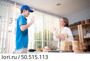 The delivery man brings the goods that the customer purchased and delivers them to the customer’s home. Стоковое фото, агентство Ingram Publishing / Фотобанк Лори