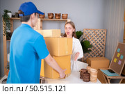 The delivery man brings the goods that the customer purchased and delivers them to the customer’s home. Стоковое фото, агентство Ingram Publishing / Фотобанк Лори
