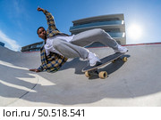 Surf skater performing a agressive slide on a skatepark during a sunny day. Стоковое фото, агентство Ingram Publishing / Фотобанк Лори