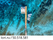 Aerial view of boats and luxure yachts in dock at sunset in summer in Sardinia, Italy. Colorful landscape with sailboats and motorboats in sea bay, jatty, clear blue sea. Top view of harbor. Travel. Стоковое фото, агентство Ingram Publishing / Фотобанк Лори