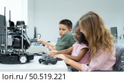 Youngsters utilizing the hand robot technology are having fun learning the electronic circuit board and hand robot controller of robot technology, which is one of the STEM courses. Стоковое фото, агентство Ingram Publishing / Фотобанк Лори
