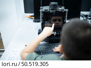 Youngsters utilizing the hand robot technology are having fun learning the electronic circuit board and hand robot controller of robot technology, which is one of the STEM courses. Стоковое фото, агентство Ingram Publishing / Фотобанк Лори