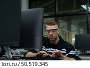 The robotic hand technology teacher is instructing new students on how to use electronic circuit boards and robotic hand commands for a variety of industrial applications. Стоковое фото, агентство Ingram Publishing / Фотобанк Лори