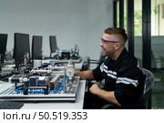 The robotic hand technology teacher is instructing new students on how to use electronic circuit boards and robotic hand commands for a variety of industrial applications. Стоковое фото, агентство Ingram Publishing / Фотобанк Лори