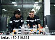 The robotic hand technology teacher is instructing new students on how to use electronic circuit boards and robotic hand commands for a variety of industrial applications. Стоковое фото, агентство Ingram Publishing / Фотобанк Лори