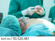 Professor of medicine in cardiology and a team of doctors in the operating room undergoing heart transplant surgery. Стоковое фото, агентство Ingram Publishing / Фотобанк Лори