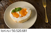 Meringue roll cake with cream and tangerine. Roulade, summer dessert served in ceramic plate. Стоковое фото, агентство Ingram Publishing / Фотобанк Лори
