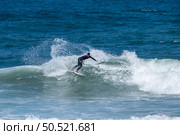 Surfer riding waves in Furadouro Beach, Portugal. Men catching waves in ocean. Surfing action water board sport. people water sport lessons and beach swimming activity on summer vacation. Стоковое фото, агентство Ingram Publishing / Фотобанк Лори