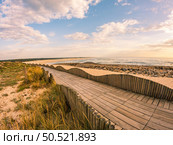 View from the walkway south of Furadouro beach in Ovar on a stormy day at sunset. Стоковое фото, агентство Ingram Publishing / Фотобанк Лори